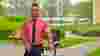 man in shirt and tie with his bike outside office building