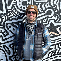 North London resident Mat Shreeve, standing in front of a graffiti wall smiling