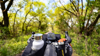 Point of view shot of bikepacking through a woodland, feautring various panniers visible from the handlebars.