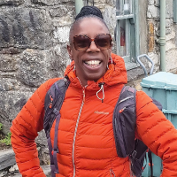 A woman smiling wearing a walking jacket.