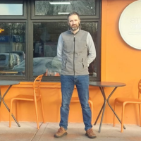 A man stood outside a coffee shop.