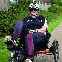 Debbie riding her recumbent trike along a traffic-free National Cycle Network route.