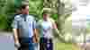 man and woman walking on hill with panoramic views behind them